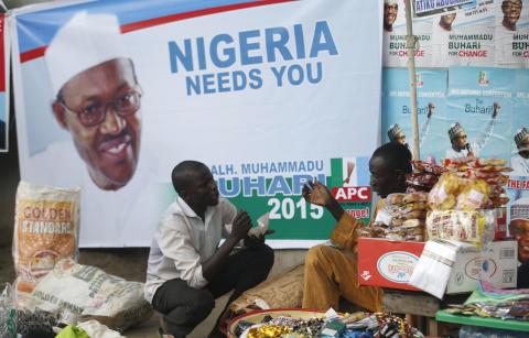 Vendors sell their wares near an election poster of former Nigerian military ruler Muhammadu Buhari before the start of All Progressives Congress (APC) party convention in Lagos, December 10, 2014. PHOTO BY REUTERS/Akintunde Akinleye