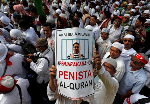 An Indonesian Muslim holds up a poster during a rally calling for the arrest of Jakarta's Governor Basuki Tjahaja Purnama, popularly known as Ahok, who is accused of insulting the Koran, in Jakarta, Indonesia, December 2, 2016. PHOTO BY REUTERS/Beawiharta