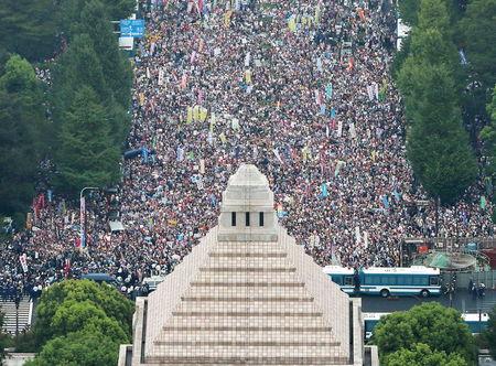 People hold placards and shout slogans as they gather to protest against Japan's Prime Minister Shinzo Abe's security bill outside the parliament in Tokyo, in this photo taken by Kyodo, August 30, 2015. PHOTO BY REUTERS/Kyodo