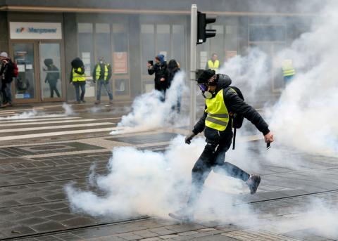 A protester returns a tear gas canister during a demonstration of the "yellow vests" movement in Strasbourg, France, January 12, 2019. PHOTO BY REUTERS/Vincent Kessler