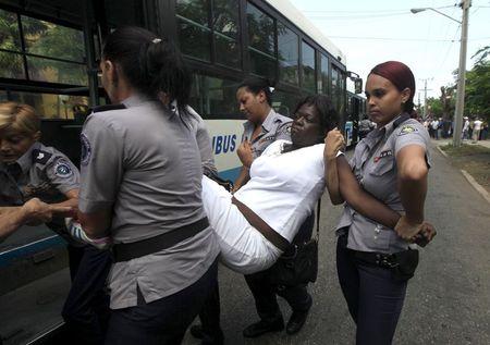 Cuban security personnel detain a member of the Ladies in White group after their weekly anti-government protest march, in Havana, September 13, 2015. PHOTO BY REUTERS/Enrique de la Osa