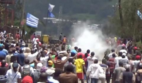 A still image taken from a video shot on October 1, 2017, shows protesters waving Ambazonian flags as they move forward towards barricades and police amid tear gas in the English-speaking city of Bamenda, Cameroon. PHOTO BY REUTERS