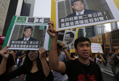 Pro-democracy protesters carrying portraits of Hong Kong Chief Executive Leung Chun-ying march to his residence in Hong Kong October 22, 2014. PHOTO BY REUTERS/Bobby Yip