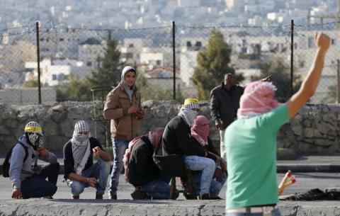 Palestinian protesters take cover during clashes with Israeli troops in the West Bank city of Bethlehem, January 13, 2016. PHOTO BY REUTERS/Ammar Awad