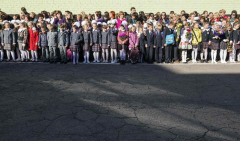 Pupils and their parents attend a festive ceremony to mark the beginning of another academic year in Makiivka, eastern Ukraine