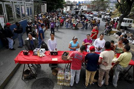 People queue to buy staple items in a Mercal, a subsidized state-run street market, in Caracas, August 4, 2015. PHOTO BY REUTERS/Carlos Garcia Rawlins