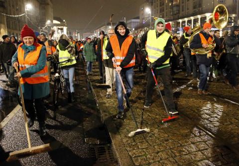 Participants of an alternative rally use brooms as they protest against a demonstration called by anti-immigration group PEGIDA, a German abbreviation for "Patriotic Europeans against the Islamization of the West", in Dresden, January 5, 2015. PHOTO BY REUTERS/Fabrizio Bensch
