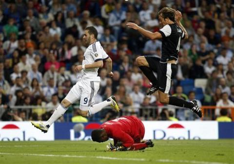 Real Madrid's Karim Benzema (L) and Malaga's Diego Alfredo Lugano
