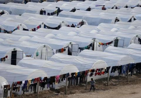 A Kurdish refugee boy from the Syrian town of Kobani walks past a refugee camp in the border town of Suruc, Sanliurfa province, November 24, 2014. PHOTO BY REUTERS/Osman Orsal