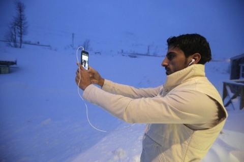 A refugee takes a selfie at the front of his camp at a hotel touted as the world's most northerly ski resort in Riksgransen, Sweden, December 15, 2015. PHOTO BY REUTERS/Ints Kalnins