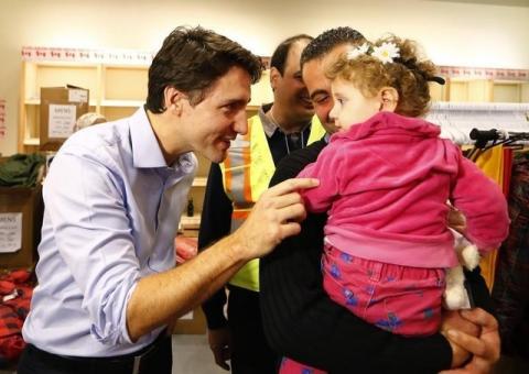 Syrian refugees are greeted by Canada's Prime Minister Justin Trudeau (L) on their arrival from Beirut at the Toronto Pearson International Airport in Mississauga, Ontario, Canada, December 11, 2015. PHOTO BY REUTERS/Mark Blinch
