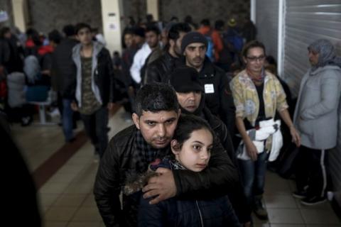 Refugees and migrants line up to receive a meal inside a terminal, moments after arriving aboard the Tera Jet passenger ship at the port of Piraeus, near Athens, Greece, February 10, 2016. PHOTO BY REUTERS/Alkis Konstantinidis