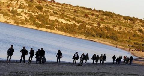 Refugees walk along a beach before trying to travel to the Greek island of Chios from the western Turkish coastal town of Cesme, in Izmir province, Turkey, March 5, 2016. REUTERS/Umit Bektas