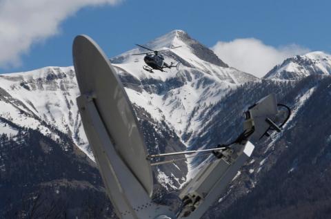 A rescue helicopter from the French Gendarmerie lands behind a media satellite dish seen during operations near the crash site of an Airbus A320, in Seyne-les-Alpes, March 26, 2015. PHOTO BY REUTERS/Jean-Paul Pelissier