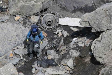 A French rescue worker inspects the debris from the Germanwings Airbus A320 at the site of the crash, near Seyne-les-Alpes, French Alps, March 29, 2015. PHOTO BY REUTERS/Gonzalo Fuentes