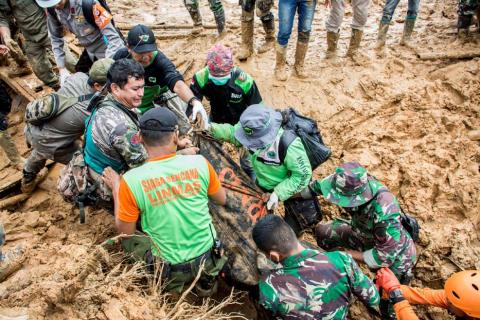 Rescue workers carry a body bag containing remains of victims following a landslide at Cisolok district in Sukabumi, West Java province, Indonesia, January 1, 2019 in this photo taken by Antara Foto. PHOTO BY REUTERS/Antara Foto/Nurul Ramadhan