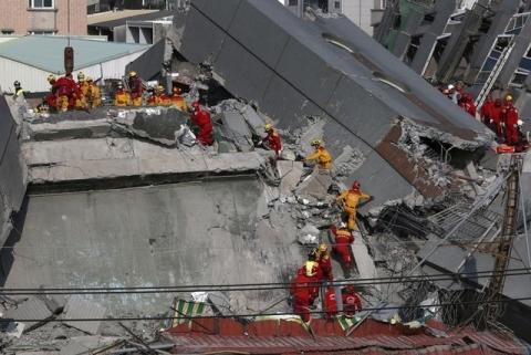 Rescue personnel search the rubble of a 17-storey apartment building that collapsed after an earthquake hit Tainan, southern Taiwan, February 7, 2016. PHOTO BY REUTERS/Tyrone Siu
