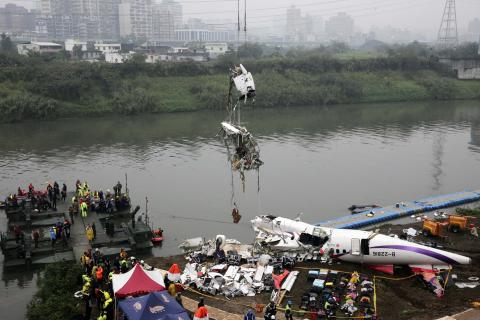 Rescuers lift part of the wreckage of TransAsia Airways plane Flight GE235 after it crash landed into a river, in New Taipei City, February 5, 2015. PHOTO BY REUTERS/Stringer