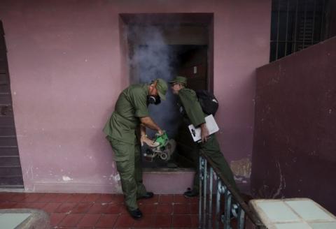 A Cuban military reservist fumigates inside a home in Havana, February 22, 2016. PHOTO BY REUTERS/Enrique de la Osa