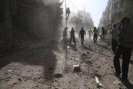 Residents inspect damage after what activists said was an airstrike by forces loyal to Syria's President Bashar al-Assad on the town of Douma, eastern Ghouta of Damascus, September 19, 2015. PHOTO BY REUTERS/Bassam Khabieh