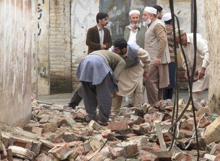 Residents gather to clear a path by removing rubble from a house after it was damaged by an earthquake in Mingora, Swat, Pakistan, October 26, 2015. PHOTO BY REUTERS/Hazrat Ali Bacha