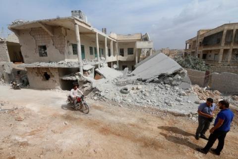 A man drives a motorcycle near a site hit by what residents said were airstrikes carried out by the Russian air force in the town of Darat Izza, in Aleppo province, Syria, October 13, 2015. PHOTO BY REUTERS/Ammar Abdullah