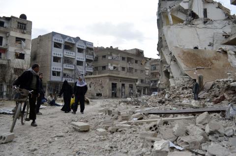 Residents walk past damaged buildings after what activists said were air strikes by forces loyal to Syria's President Bashar al-Assad in the Douma neighborhood of Damascus, February 6, 2015. PHOTO BY REUTERS/Amer Almohibany