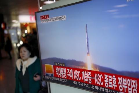 A passenger walks past a TV screen broadcasting a news report on North Korea's long range rocket launch at a railway station in Seoul, South Korea, February 7, 2016. PHOTO BY REUTERS/Kim Hong-Ji