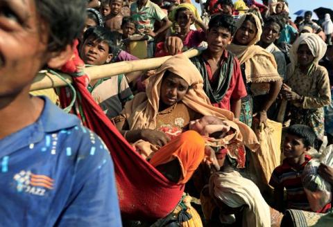 Fsarul Begum, a Rohingya refugee who fled from Myanmar is carried with her new born baby as they wait to be let through after crossing the border in Palang Khali, Bangladesh, October 16, 2017. PHOTO BY REUTERS/Zohra Bensemra