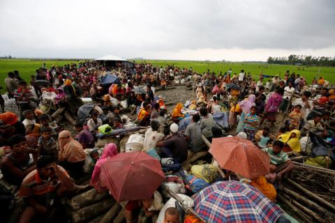 Rohingya refugees sit as they are temporarily held by the Border Guard Bangladesh (BGB) in an open area after crossing the border, in Teknaf, Bangladesh, September 3, 2017. PHOTO BY REUTERS/Mohammad Ponir Hossain