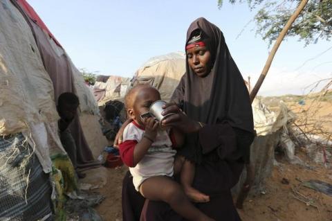Rukia Nur feeds her child outside her makeshift dwelling after fleeing famine in the Marka Lower Shebbele regions to the capital Mogadishu, September 20, 2014. PHOTO BY REUTERS/Feisal Omar