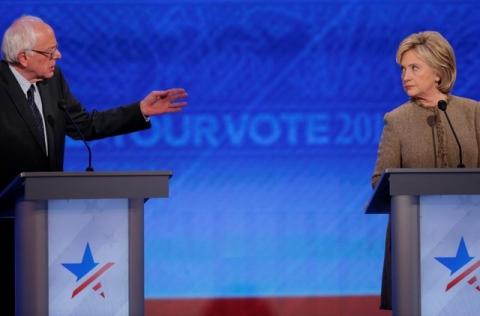 Democratic U.S. presidential candidate and former Secretary of State Hillary Clinton listens as U.S, Senator Bernie Sanders answers a question at the Democratic presidential candidates debate at St. Anselm College in Manchester, New Hampshire, December 19, 2015. PHOTO BY REUTERS/Brian Snyder
