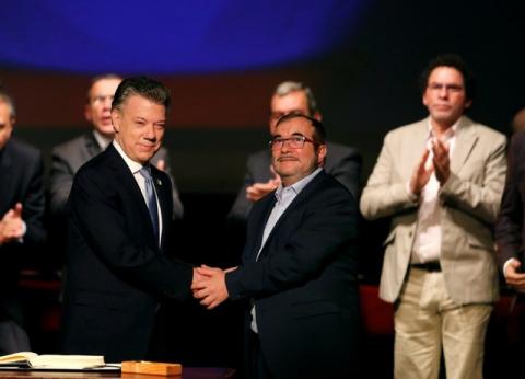 Colombia's President Juan Manuel Santos and Marxist FARC rebel leader Rodrigo Londono, known as Timochenko, shake hands after signing a peace accord in Bogota, Colombia, November 24, 2016. PHOTO BY REUTERS/Jaime Saldarriaga