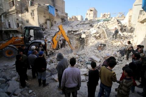 Civil defence members search for survivors after airstrikes by pro-Syrian government forces in the rebel held al-Qaterji neighbourhood of Aleppo, Syria, February 14, 2016. PHOTO BY REUTERS/Abdalrhman Ismail