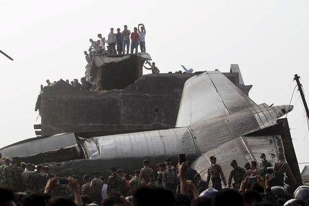 Security forces and residents examine the wreckage of an Indonesian military C-130 Hercules transport plane after it crashed into a residential area in the North Sumatra city of Medan, Indonesia, June 30, 2015. PHOTO BY REUTERS/Roni Bintang