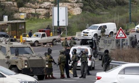 Israeli security forces gather near the scene of what the Israeli military said were back-to-back gun and car-ramming attacks by Palestinians, near the Jewish settlement of Kiryat Arba near the West Bank city of Hebron, March 14, 2016. PHOTO BY REUTERS/Mussa Qawasma