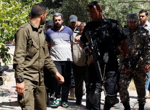 Members of Palestinian security forces loyal to Hamas escort an alleged collaborator with Israel, who was convicted in participating in killing senior Hamas commander Mazen Fuqaha, as he arrives to a Hamas-run military court in Gaza City, May 21, 2017. PHOTO BY REUTERS/Mohammed Salem