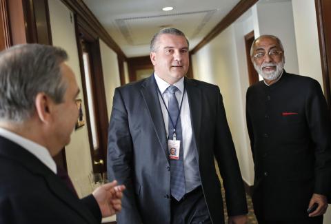 Sergey Aksyonov (C), the leader of Crimea, the former Ukrainian territory annexed by Russia, walks inside a hotel after having his lunch as Indian businessman Gul Kripalani (R) watches, in New Delhi, December 11, 2014. PHOTO BY REUTERS/Anindito Mukherjee