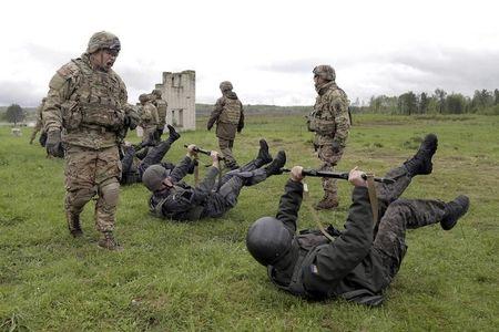 Servicemen of the U.S. Army's 173rd Airborne Brigade Combat Team (standing) train members of the Ukrainian National Guard during a joint military exercise called "Fearless Guardian 2015" at the International Peacekeeping and Security Center near the western village of Starychy, Ukraine, May 7, 2015. PHOTO BY REUTERS/Roman Baluk