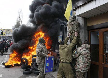 Servicemen from the Aydar battalion throw a Ukrainian flag from the building of Ukraine's Defence Ministry, during a protest against the disbanding of the battalion, in Kiev, Ukraine, in this February 2, 2015 file photo. PHOTO BY REUTERS/Valentyn Ogirenko