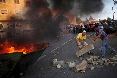 Jewish settlers use rocks to block a road during clashes with Israeli security forces near buildings slated for demolition by order of Israel's high court, in the West Bank Jewish settlement of Beit El, near Ramallah, July 28, 2015. PHOTO BY REUTERS/Amir Cohen
