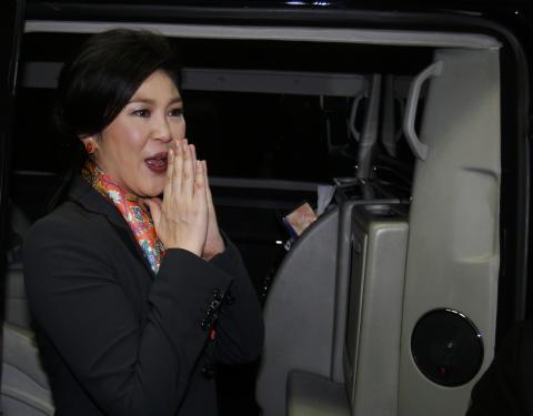 Thailand's Prime Minister Yingluck Shinawatra gives a traditional greeting as she leaves the Permanent Secretary of Defence office in Bangkok