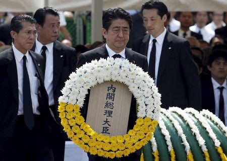 Japan's Prime Minister Shinzo Abe offers a flower wreath for the victims of the 1945 atomic bombing, during a ceremony commemorating the 70th anniversary of the bombing of the city at Nagasaki's Peace Park in western Japan, August 9, 2015. PHOTO BY REUTERS/Toru Hanai