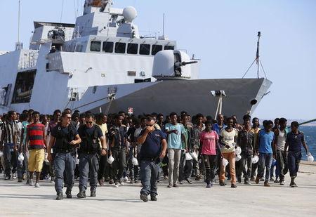 Migrants disembark from an Italian navy vessel in the Sicilian harbour of Augusta, Italy, August 23, 2015. REUTERS/Antonio Parrinello