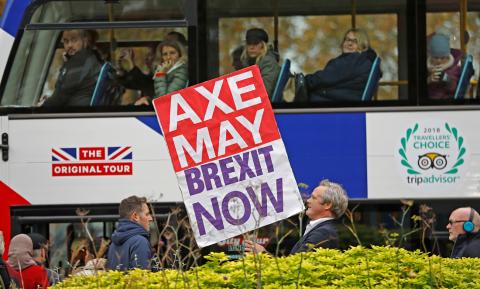A pro-Brexit campaigner holds a placard as a tourist bus passes by in Westminster London, Britain, November 16, 2018. PHOTO BY REUTERS/Peter Nicholls
