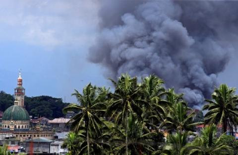 Black smoke comes from a burning building as government troops continue their assault against insurgents from the Maute group, who have taken over large parts of Marawi city, Philippines, June 14, 2017. PHOTO BY REUTERS/Romeo Ranoco