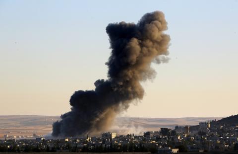 Thick black smoke rises over an eastern Kobani neighborhood following an air strike on November 8, 2014. PHOTO BY REUTERS/Yannis Behrakis