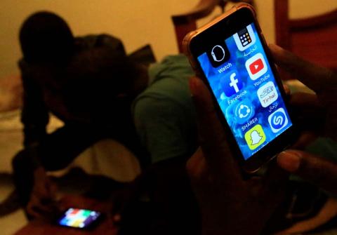 A Sudanese man holds his phone with restricted internet access social media platforms, in Khartoum, Sudan, January 1, 2019. PHOTO BY REUTERS/Mohamed Nureldin Abdalla