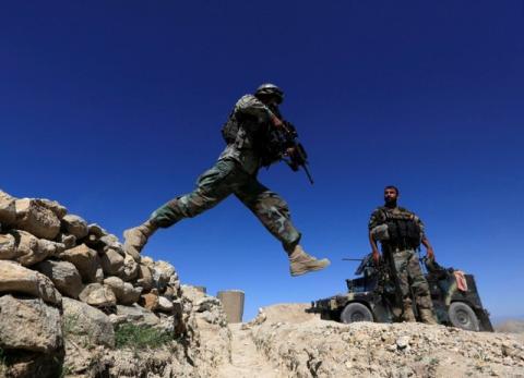 A member of Afghanistan's Special Forces unit jumps from a wall during patrol in Pandola village near the site of a U.S. bombing in the Achin district of Nangarhar, eastern Afghanistan, April 14, 2017. PHOTO BY REUTERS/Parwiz