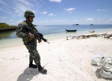 A Filipino soldier patrols at the shore of Pagasa island (Thitu Island) in the Spratly group of islands in the South China Sea, west of Palawan, Philippines, May 11, 2015. PHOTO BY REUTERS/Ritchie B. Tongo